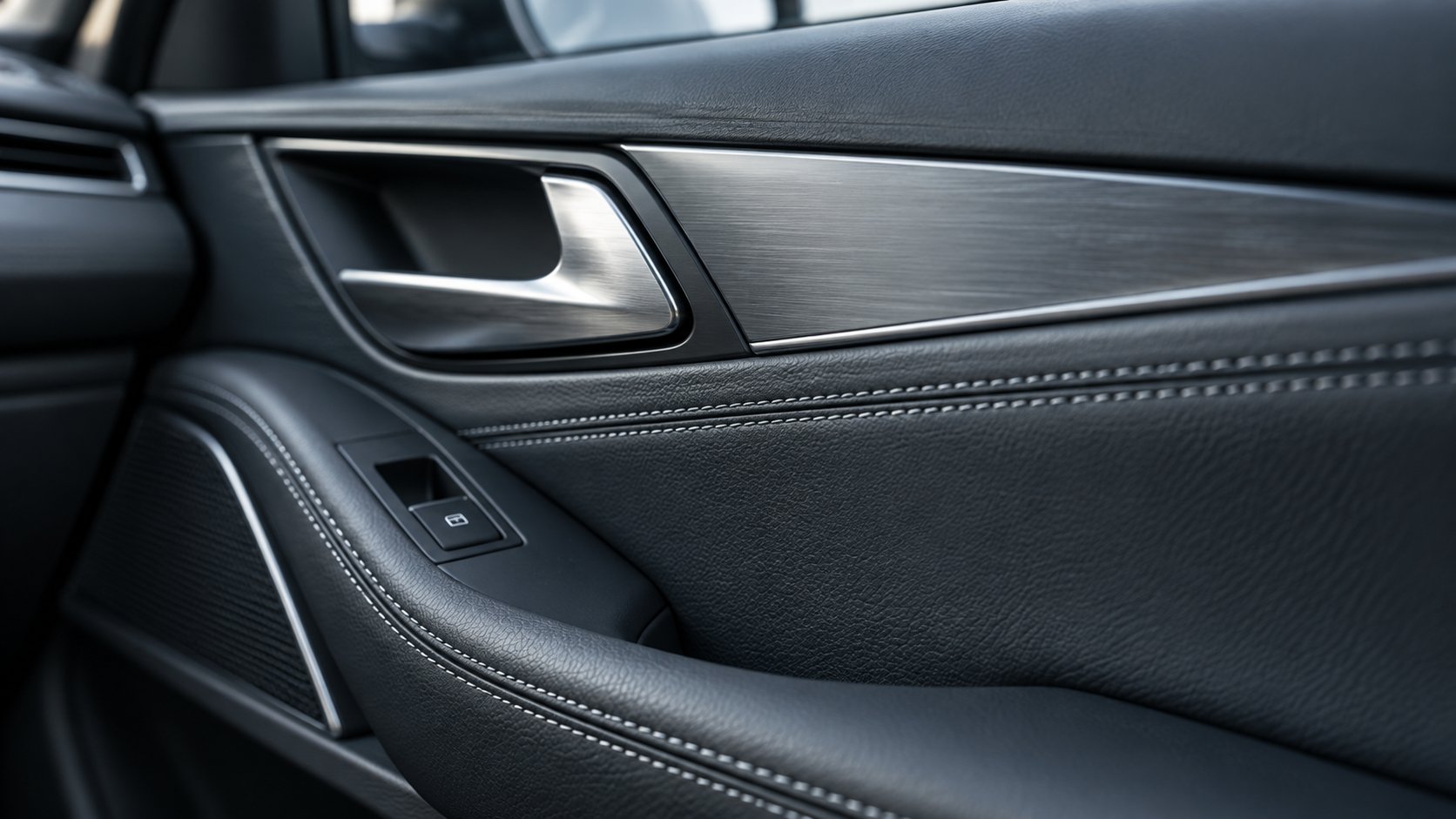 Ilustrativní detail koženého čalounění, přesného šití a kovového obložení dveří automobilu